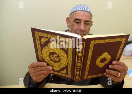 Le directeur de la mosquée islamique de Vendrell Hassan Smini lit des chapitres du Livre Saint du Coran pendant le Ramadan avant la prière de la cinquième nuit. La communauté musulmane d'El Vendrell célèbre le Ramadan et leur rassemblement à la mosquée islamique de la ville pour effectuer la prière de nuit appelée 'Isha'. Dans Vendrell il y a environ 2 600 personnes enregistrées de différentes nationalités et leur religion est l'Islam, outre les fils et les filles de ces immigrés déjà nés en Espagne, où il y a environ 3 000 musulmans dans une ville d'environ 39 000 habitants. Avant de prier, les hommes se lavent les mains, m Banque D'Images