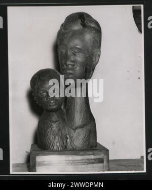 Description : un bel exemple de sculpture sur bois haïtien. La sculpture représente une mère et un enfant et a été présentée par la Croix-Rouge haïtienne à S.M. S.'Vidal' en reconnaissance du travail accompli par le navire pour soulager la détresse après l'ouragan ''Hazel'' en 1954. Lieu : Haïti date : juin 1956 haïti, caraïbes, caribbeanthralens Banque D'Images