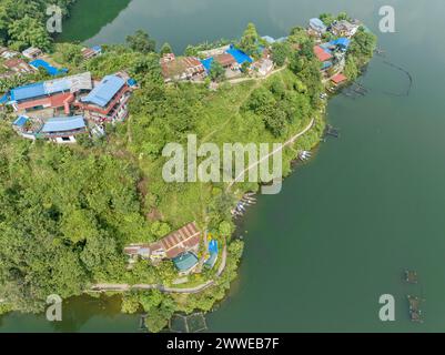Vue aérienne du lac Begnas le troisième plus grand lac du Népal. Nature sauvage et arbres avec des maisons entourent le lac, bateaux népalais typiques dans l'eau Banque D'Images