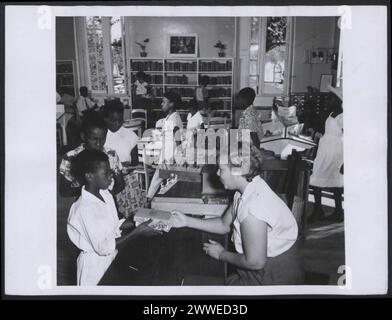 Section pour mineurs de la Bibliothèque publique de Bridgetown (Barbade), présentant un espace de lecture, des étagères et un environnement éducatif pour les enfants en mars 1955. Banque D'Images