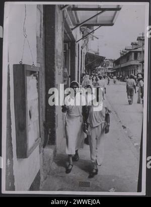 Description : Trinité-et-Tobago. Conditions de travail dans les Antilles. Les femmes indiennes (des Indes orientales) vont faire du shopping dans le Port d'Espagne. Photographie n° : MOI/8705A. Photographie officielle de Trinité-et-Tobago compilée par le Bureau central de l'information. Cachet à la main du Ministère de l'information, Division de la photographie, au verso. Copyright de Mme Muir, 23 Creswick Walk, Londres, NW11. Lieu : Trinité-et-Tobago date : [1945] caraïbes, caribbeanthrough alens Banque D'Images