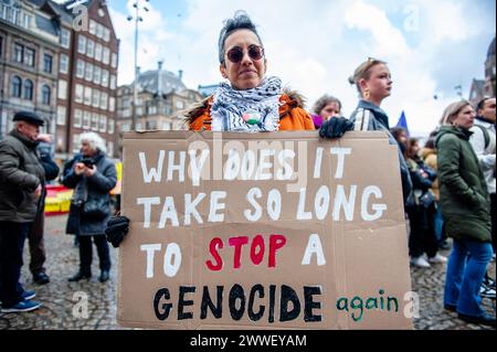 Amsterdam, pays-Bas. 23 mars 2024. Une femme est vue tenant une grande pancarte contre le génocide. Des personnes se sont rassemblées sur la place du Dam à Amsterdam pour demander la diversité, la solidarité et contre toutes les formes de racisme et de discrimination pour marquer la Journée de l’élimination de la discrimination raciale. Crédit : SOPA images Limited/Alamy Live News Banque D'Images