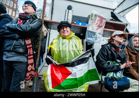 Amsterdam, pays-Bas. 23 mars 2024. Une femme est vue tenant un drapeau palestinien tout en écoutant des discours. Des personnes se sont rassemblées sur la place du Dam à Amsterdam pour demander la diversité, la solidarité et contre toutes les formes de racisme et de discrimination pour marquer la Journée de l’élimination de la discrimination raciale. (Photo par Ana Fernandez/SOPA images/SIPA USA) crédit : SIPA USA/Alamy Live News Banque D'Images