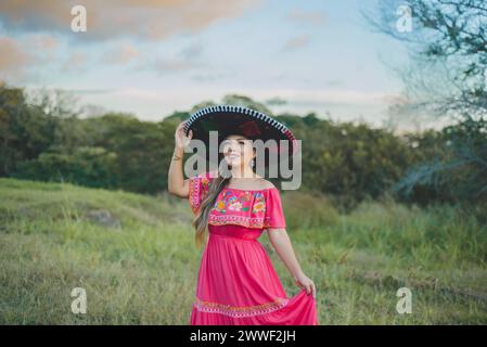 Femme mexicaine portant un chapeau et une robe traditionnels. Portrait dans un cadre campagnard. Banque D'Images