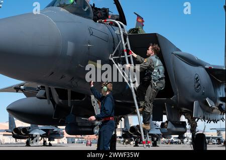 Le capitaine William Briscoe de l'US Air Force, à droite, pilote du 389th Fighter Squadron, monte dans un F-15E Strike Eagle tandis que l'aviateur senior Blaze Winzenried, technicien de phase du 389th Fighter Generation Squadron, effectue des vérifications préalables au vol lors d'un exercice Red Flag-Nellis 24-2 à la base aérienne de Nellis, Nevada, le 21 mars 2024. Les exercices drapeau rouge offrent aux équipages aériens l'expérience de plusieurs sorties de combat aérien intensives dans la sécurité d'un environnement d'entraînement. (Photo de l'US Air Force par Airman 1st Class Brianna Vetro) Banque D'Images