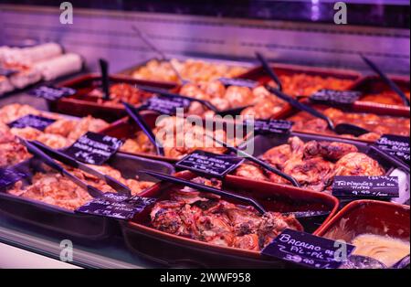 Cette image capture la variété culinaire exquise offerte par un magasin, présentant avec élégance une sélection de plats préparés. Derrière le comptoir en verre, Banque D'Images