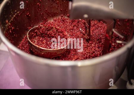 L'image représente un hachoir à viande industriel en fonctionnement, avec de la viande fraîchement hachée produite pour le remplissage de saucisses. La machine fait partie d'une viande Banque D'Images