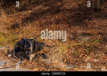 Des morceaux de chaise de bureau cassés se trouvent abandonnés au bord de la route avec de l'herbe sèche, en Corée du Sud Banque D'Images