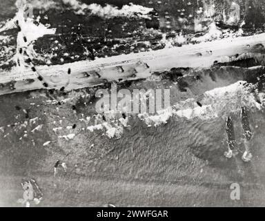 Normandie, France, 10 juin 1944 des engins d'assaut belent leur cargaison de soldats sur les plages d'invasion de Normandie en France. Les petites taches visibles dans l'eau à coiffe blanche sont des troupes pataugeantes vers le rivage. Les chars et autres véhicules à moteur ont déjà commencé à circuler à l'intérieur des terres. De plus gros engins attendent au large alors que la bataille pour la libération de l'Europe se déroule comme prévu. Banque D'Images