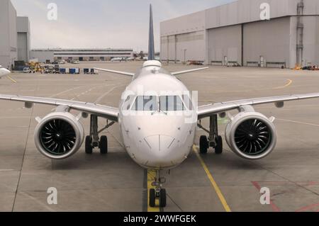 Vue de face d'un avion de ligne twinjet moderne assis sur le tarmac en béton avec des marquages de voie dans un grand aéroport Banque D'Images