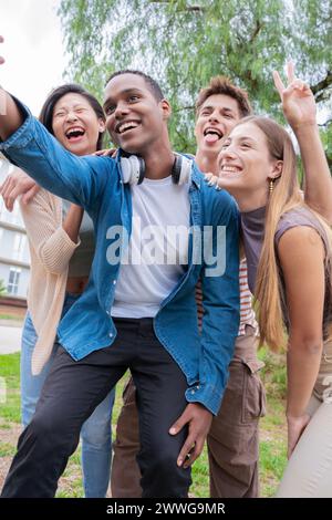 Portrait vertical groupe multiracial d'amis étudiants riant en prenant un selfie Banque D'Images