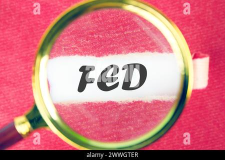 La réserve fédérale ( FED ) pour contrôler les taux d'intérêt mondes à travers une loupe sous un morceau de papier déchiré Banque D'Images