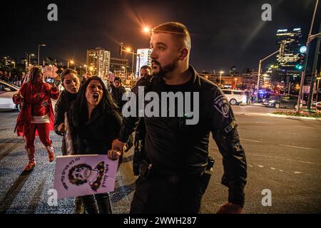 Tel Aviv, Israël. 23 mars 2024. Noam Dan, un membre de la famille de l'otage israélien Ofer Kalderon crie alors qu'il est traîné d'un carrefour par des policiers. Des milliers de manifestants contre le premier ministre Benjamin Netanyahu ont rejoint les familles israéliennes d'otages exigeant un accord immédiat d'otages, un cessez-le-feu et des élections générales dans l'État d'Israël. Des affrontements avec la police israélienne ont eu lieu après que des manifestants eurent allumé quelques feux de camp devant le quartier général des FDI et sur l'autoroute Ayalon, 15 ont été arrêtés. Crédit : SOPA images Limited/Alamy Live News Banque D'Images