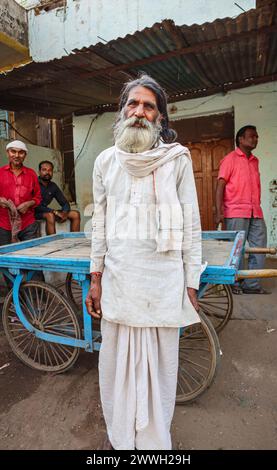 Homme indien âgé lourdement barbu en robe quotidienne typique debout sur le bord de la route dans une ville dans le district d'Umaria du Madhya Pradesh, Inde Banque D'Images