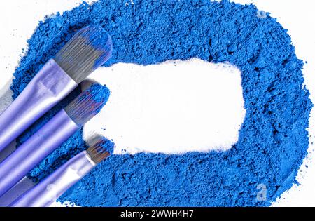 pinceaux cosmétiques sur colorant sec bleu, place pour le texte Banque D'Images