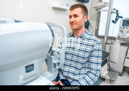 Homme sur le point de scanner son oeil dans un scanner dans une clinique Banque D'Images