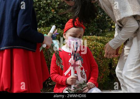 Camille, une patiente libanaise de 5 ans atteinte d’un cancer, tient une bougie alors qu’elle assiste à la messe du dimanche des Rameaux à l’église de Bkerki, au nord de Beyrouth Banque D'Images