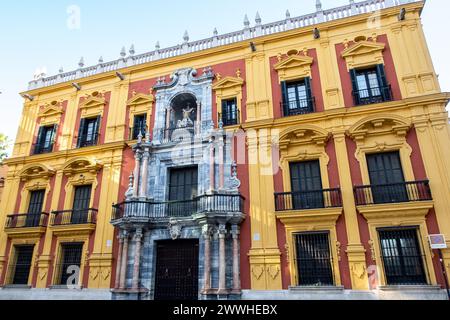Palais épiscopal (Palacio épiscopal, Palais des évêques) sur la place Obispo, Malaga, Andalousie, Espagne avec une façade baroque espagnole colorée jaune et rouge. Banque D'Images