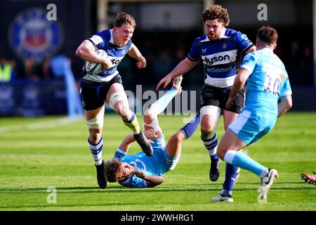 Ted Hill de Bath (à gauche) évite d'être attaqué par Gus Warr de Sale Sharks (au sol) lors du Gallagher Premiership match au Recreation Ground, Bath. Date de la photo : dimanche 24 mars 2024. Banque D'Images