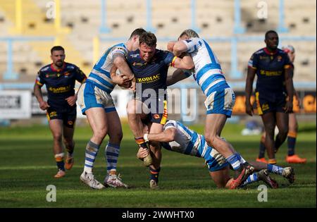 Paul Seguier des Catalans Dragons est attaqué par Ben Kavanagh, Ryan Lannon et Ben Tibbs des Halifax Panthers lors du match de la Coupe défi Betfred au stade Shay, à Halifax. Date de la photo : dimanche 24 mars 2024. Banque D'Images