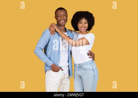 Un jeune couple afro-américain joyeux dans des vêtements décontractés se tient embrassant Banque D'Images