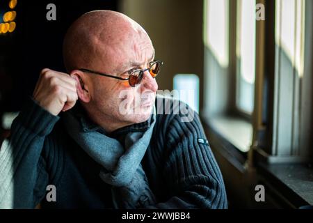 Homme réfléchissant regardant par la fenêtre Rotterdam, pays-Bas. Homme chauve-souris d'âge mûr surplombant la rivière depuis sa table de déjeuner de restaurant, tout en faisant face à une dépression. MRYES Rotterdam Hotel New York Zuid-Holland Nederland Copyright : xGuidoxKoppesx Banque D'Images