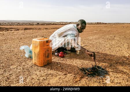 Mauritanie, environs de M'Hareth, homme préparant le thé au bord d'une piste Banque D'Images