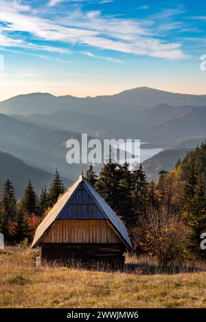 Belle vue sur la petite cabane en bois et le lac Zaovine avant le coucher du soleil au point de vue Zmajevac, montagne Tara, Serbie. Banque D'Images