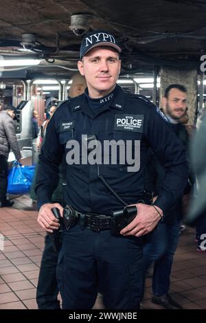 Policier sur la garde New York City, USA. Homme de police caucasien sur la garde à l'intérieur d'une station de métro du centre-ville de Manhattan, juste après les attentats terroristes de Bruxelles. New York City Union Square Subway Station, dow New York États-Unis Copyright : xGuidoxKoppesx Banque D'Images