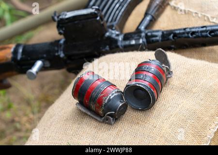 Deux grenades à main rouges noires sur des sacs de sable à l'arrière-plan d'une mitrailleuse de la seconde Guerre mondiale Banque D'Images