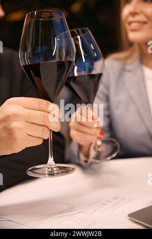 Femelle et mâle communiquent autour d'un verre de vin rouge Banque D'Images