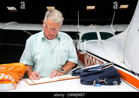 Journal de dépôt pilote Aéroport de Seppe, pays-Bas. Petit Cesna pilote travaillant sur son journal et sa comptabilité après un court vol. MRYES. Oudenbosch Vliegveld Seppe / Breda Internat Noord-Brabant Nederland Copyright : xGuidoxKoppesx Banque D'Images