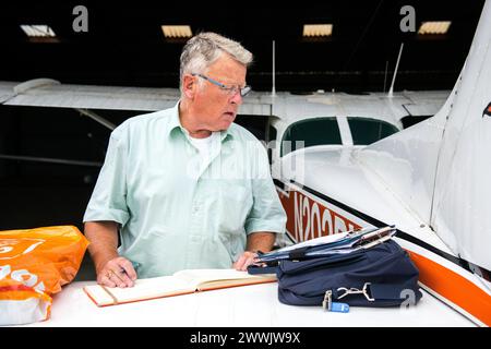 Journal de dépôt pilote Aéroport de Seppe, pays-Bas. Petit Cesna pilote travaillant sur son journal et sa comptabilité après un court vol. MRYES. Oudenbosch Vliegveld Seppe / Breda Internat Noord-Brabant Nederland Copyright : xGuidoxKoppesx Banque D'Images