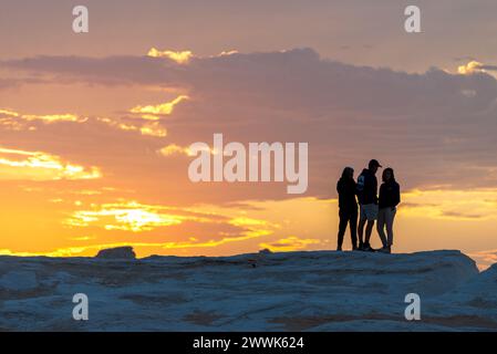 Amis en silhouette au coucher du soleil au sommet des roches de craie, Désert Blanc, Égypte Banque D'Images