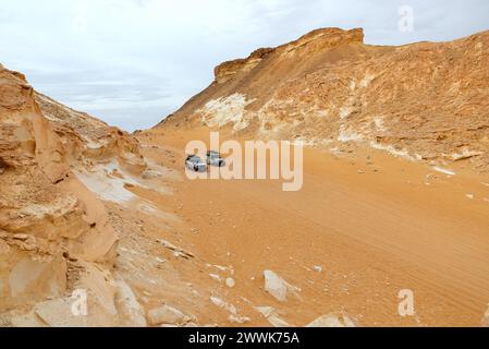 Deux véhicules 4x4 garés dans un canyon désertique rocheux, vallée d'Agabat, Égypte Banque D'Images