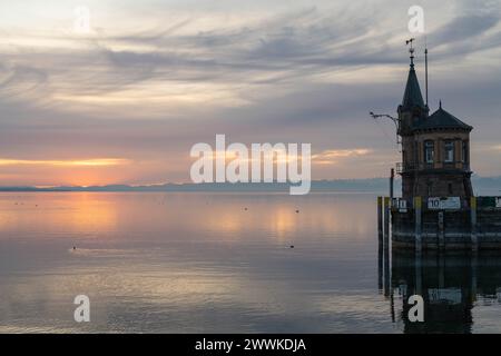 Beschreibung : Der Leuchtturm an der Hafeneinfahrt mit dem ruhigen See und den Bergen am Horizont in der Morgendämmerung. Konstanz, Bodensee, Bade-Wür Banque D'Images