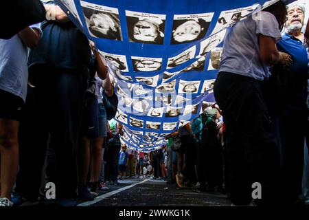 Buenos Aires, Argentine. 24 mars 2024. Les manifestants arborent une banderole avec des portraits de personnes disparues, victimes de la dernière dictature militaire Argentine, alors qu'ils défilent lors d'une manifestation pour commémorer le 48e anniversaire du coup d'État militaire de 1976. Les Argentins se souviennent des victimes de la dictature militaire en commémoration de la Journée nationale du souvenir pour la vérité et la justice. Crédit : SOPA images Limited/Alamy Live News Banque D'Images