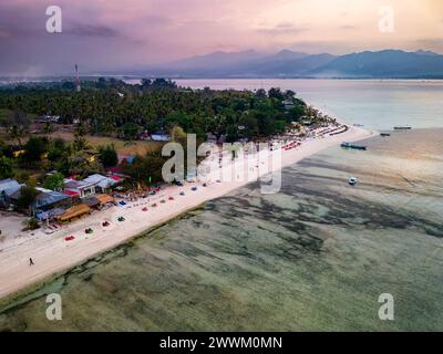 Vue aérienne d'une station balnéaire sur une petite île tropicale au coucher du soleil (Gili Air, Indonésie) Banque D'Images