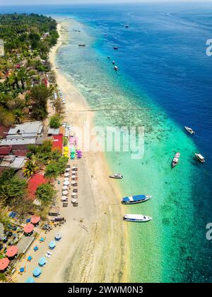 Vue aérienne d'une station balnéaire tropicale à côté d'un récif corallien sur une petite île (Gili Air, Indonésie) Banque D'Images