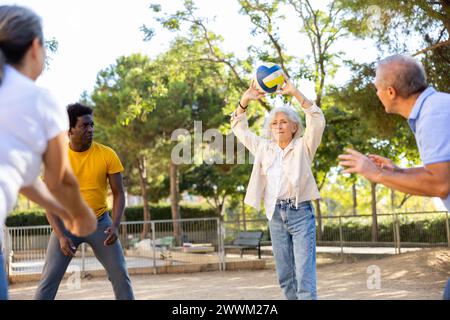 De vieilles multinationales jouent au volley-ball sur une aire de jeux d'été pour les sports au printemps dehors Banque D'Images