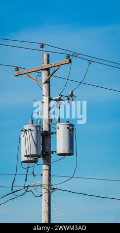 Un grand poteau utilitaire avec lignes électriques aériennes et deux seaux suspendus Banque D'Images