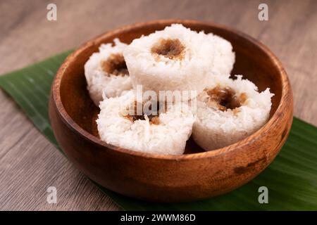 Gros plan sur le putu bambu ou le gâteau à la farine de riz cuit à la vapeur avec une garniture de noix de coco râpée et de sucre de palme Banque D'Images