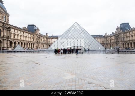 5 décembre 2023- touristes devant la pyramide de verre à l'entrée du Musée du Louvre à Paris, France Banque D'Images