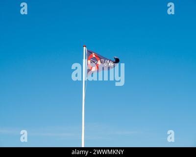 Drapeau triangulaire flottant avec le signe et le nom de l'île de Tunø contre un ciel bleu, Midtjylland, Danemark Banque D'Images