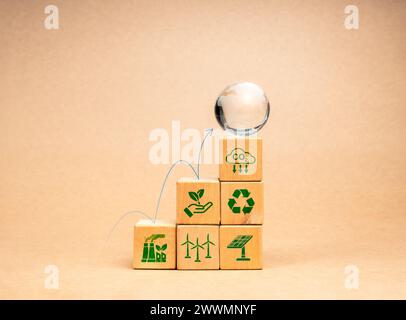 Processus de durabilité environnementale, concept de réduction des émissions de carbone. La flèche sautant jusqu'à globe de terre de verre sur le graphique cube en bois étapes avec re Banque D'Images