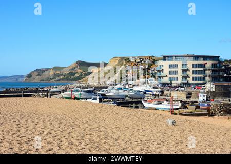 Bateaux en cale sèche avec le bâtiment Ellipse le long du quai et de la côte à l'arrière, West Bay, Dorset, Royaume-Uni, Europe. Banque D'Images