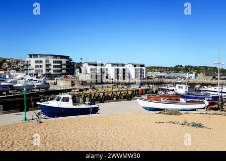 Bateaux en cale sèche avec le bâtiment Ellipse et le long du quai à l'arrière, West Bay, Dorset, Royaume-Uni, Europe. Banque D'Images