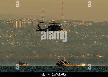 Un MH-60S Seahawk affecté aux « wildcards » de l’Helicopter Sea combat Squadron 23 simule le personnel de récupération attaché dans une civière de litière pendant la formation de récupération maritime dans la baie de San Diego, le 14 février 2024. Des marins attachés au quai de transport amphibie USS San Diego (LPD 22), à l’unité de soutien expéditionnaire 1 de l’élimination des engins explosifs et au Helicopter Sea combat Squadron 23 « Wildcards » se sont entraînés aux côtés de la NASA avant le test de récupération 11 en cours. En préparation de la mission Artemis II Crewed de la NASA, qui enverra quatre astronautes à Orion au-delà de la Lune, la NASA et le Département de la Défense Banque D'Images