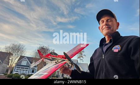 Charlie Lilli, commandant adjoint de Defense Logistics Agency Aviation et passionné d'avions RC, tient l'un de ses modèles acrobatiques prisés. Sa collection de 25 avions et hélicoptères radiocommandés, qu'il pilote adeptement, incarne son amour du vol. Banque D'Images