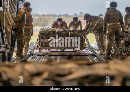 Des aviateurs du 420th munitions Squadron poussent des palettes à bord d'un C-17 Globemaster III, affecté au 21st Airlift Squadron, pour le transport aérien à la RAF Fairford, en Angleterre, le 9 février 2024. Des opérations comme celle-ci permettent à la 501e Escadre de soutien au combat d'accomplir des tâches dirigées par le siège plus haut plus rapidement que le processus standard et permettent d'expédier une plus grande quantité de munitions. Une seule mission de transport aérien peut économiser plus de sept semaines de travail ainsi que mettre en évidence les capacités d'emploi de combat agile que le 501st offre. Armée de l'air Banque D'Images